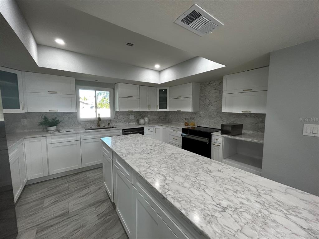 6370 Conniewood Square New Port Richey, FL 34653 - Photo 26 of 27 a kitchen with a sink stove and cabinets