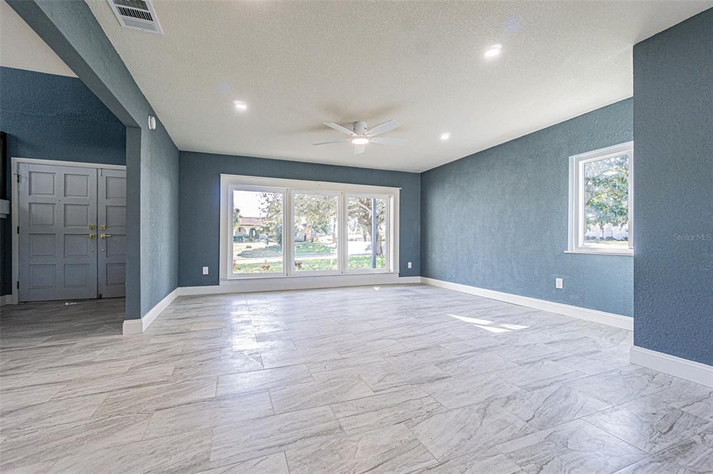 6370 Conniewood Square New Port Richey, FL 34653 - Photo 3 of 27 a view of an empty room with a window and wooden floor