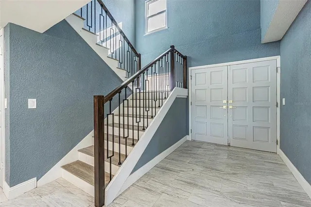 a view of staircase with railing and white walls