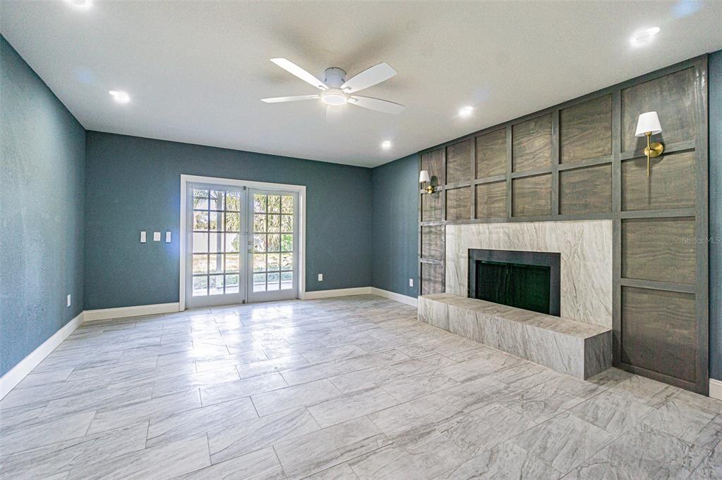 6370 Conniewood Square New Port Richey, FL 34653 - Photo 7 of 27 a view of an empty room with a fireplace and a window
