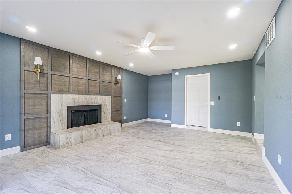 6370 Conniewood Square New Port Richey, FL 34653 - Photo 8 of 27 a view of an empty room with a fireplace and a window