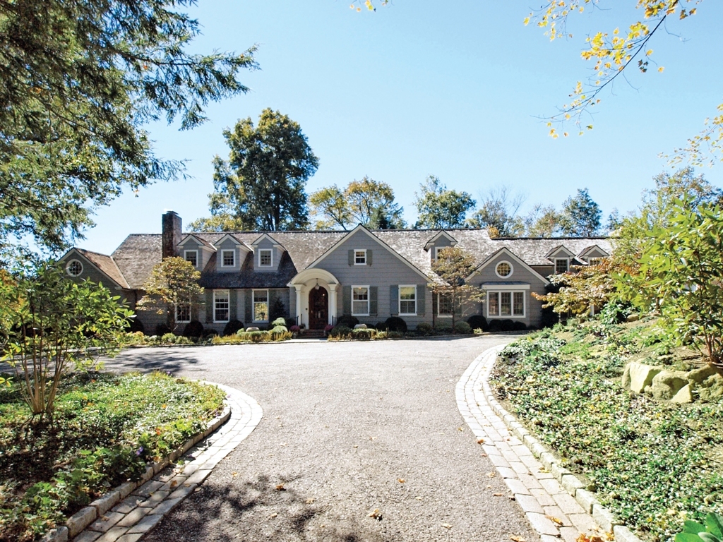 230 Rosebrook Road New Canaan, CT 06840 - Photo 1 of 25 a front view of a house with a yard covered with trees
