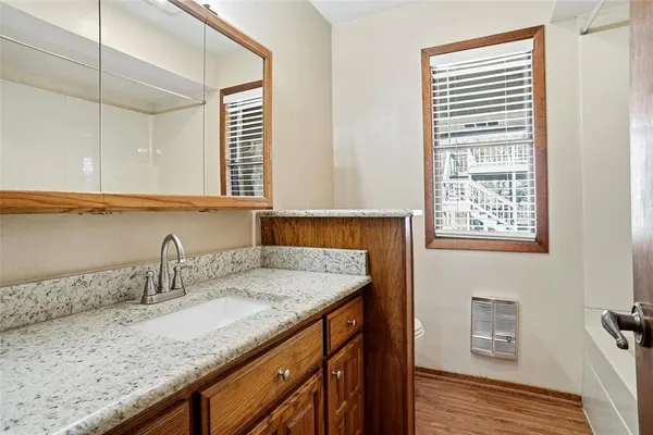 a bathroom with a granite countertop sink and a mirror
