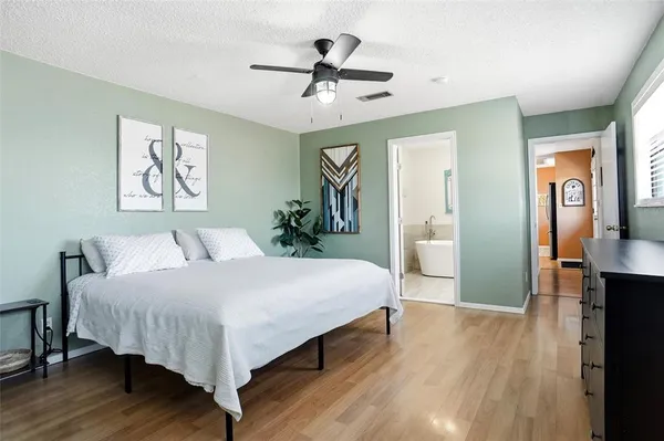 a spacious bedroom with a large bed and a chandelier
