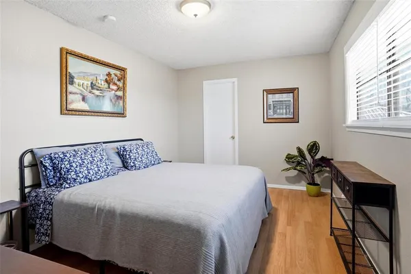 a bedroom with a bed and wooden floor