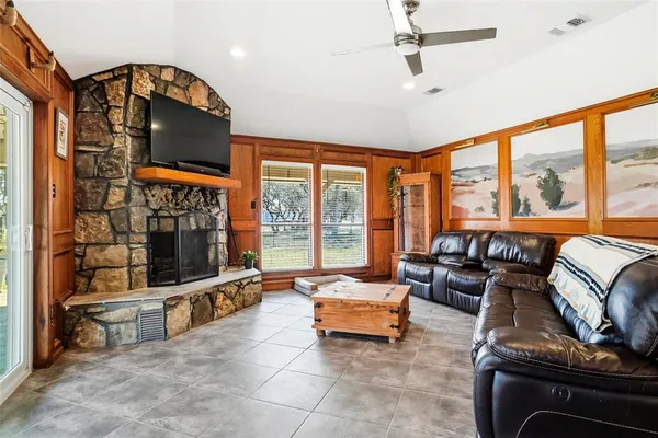 a living room with furniture a flat screen tv and floor to ceiling window