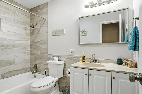 a bathroom with a sink a toilet a mirror and shower