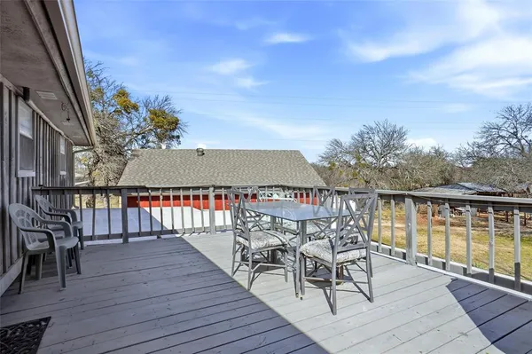 a view of a balcony with chairs and wooden floor