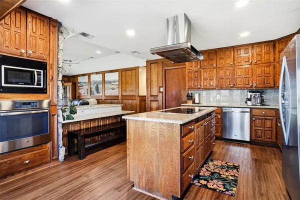a kitchen with stainless steel appliances granite countertop a stove a sink and a refrigerator