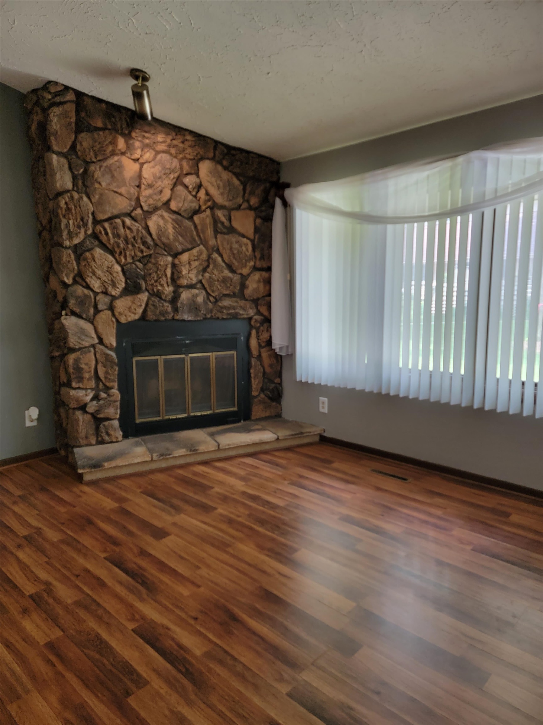 4685 High Point Drive Rockford, IL 61114 - Photo 5 of 20 a view of an empty room with wooden floor and a fireplace