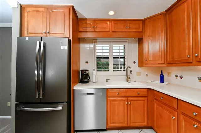a kitchen with stainless steel appliances granite countertop a refrigerator and a sink