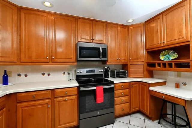a kitchen with granite countertop wooden cabinets and a stove top oven