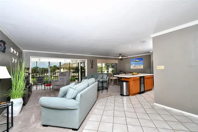 a living room with furniture a flat screen tv and a floor to ceiling window