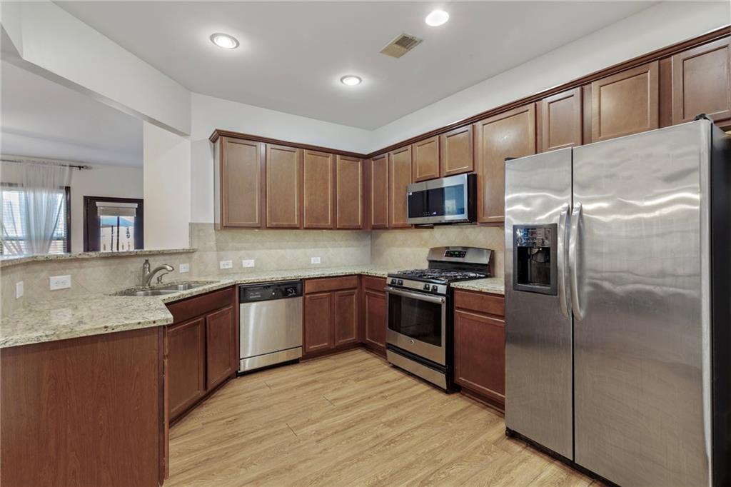 4430 Cedar Bridge Walk Suwanee, GA 30024 - Photo 12 of 29 a kitchen with stainless steel appliances granite countertop a refrigerator sink and microwave