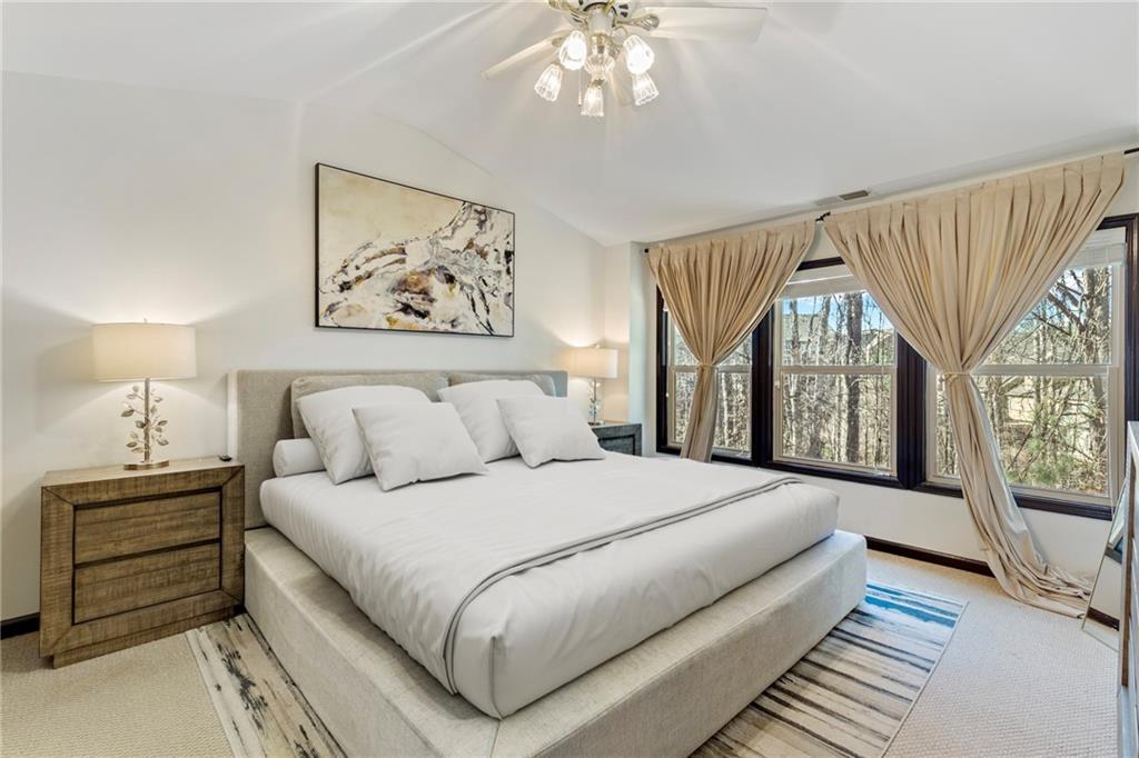 4430 Cedar Bridge Walk Suwanee, GA 30024 - Photo 18 of 29 a bedroom with a large bed and a chandelier