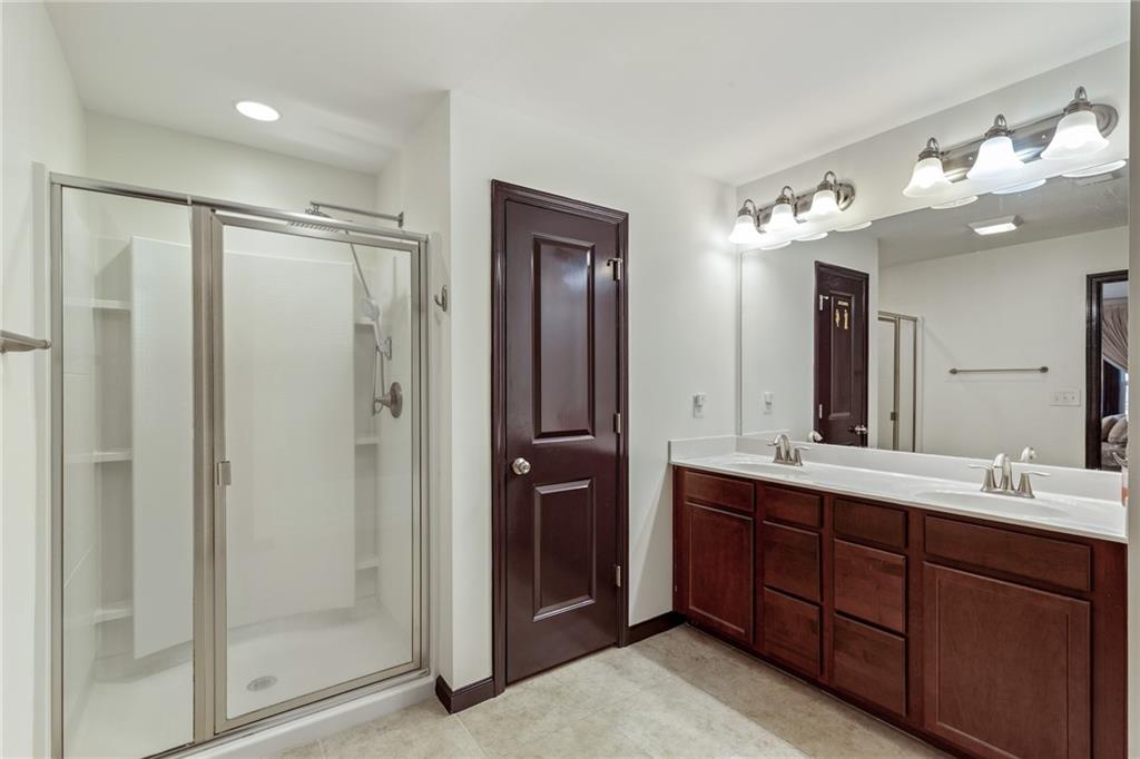 4430 Cedar Bridge Walk Suwanee, GA 30024 - Photo 21 of 29 a bathroom with a double vanity sink and mirror with shower