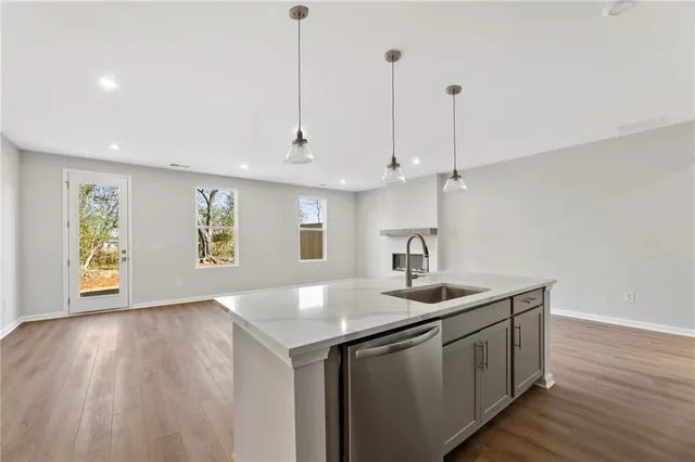 a kitchen with a sink window and wooden floor