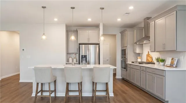 a kitchen with stainless steel appliances kitchen island granite countertop a dining table chairs and sink