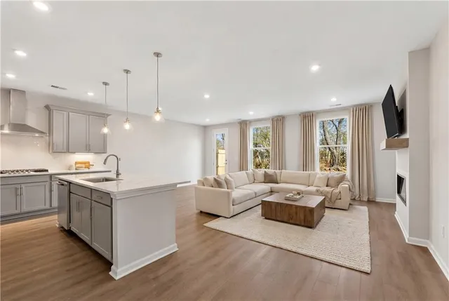 a open kitchen with stainless steel appliances granite countertop a stove oven and a refrigerator with wooden floor