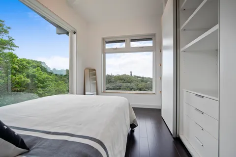 a view of a bedroom with wooden floor and windows