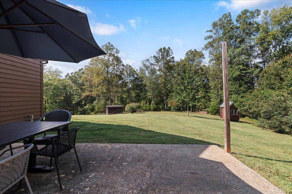 181 Mobley Mountain Road Amherst, VA 24521 - Photo 78 of 98 a view of a backyard with table and chairs under an umbrella