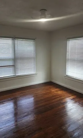 a view of empty room with wooden floor