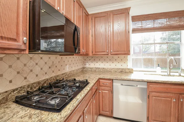 a kitchen with stainless steel appliances granite countertop a refrigerator and a sink