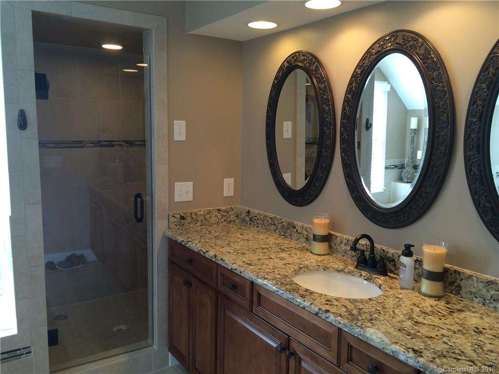 4732 Binfords Ridge Road Charlotte, NC 28226 - Photo 8 of 13 a bathroom with a granite countertop sink a mirror and a shower
