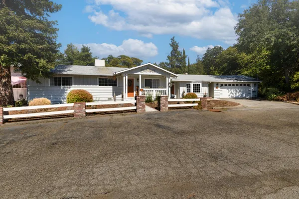 a view of a house with backyard and trees