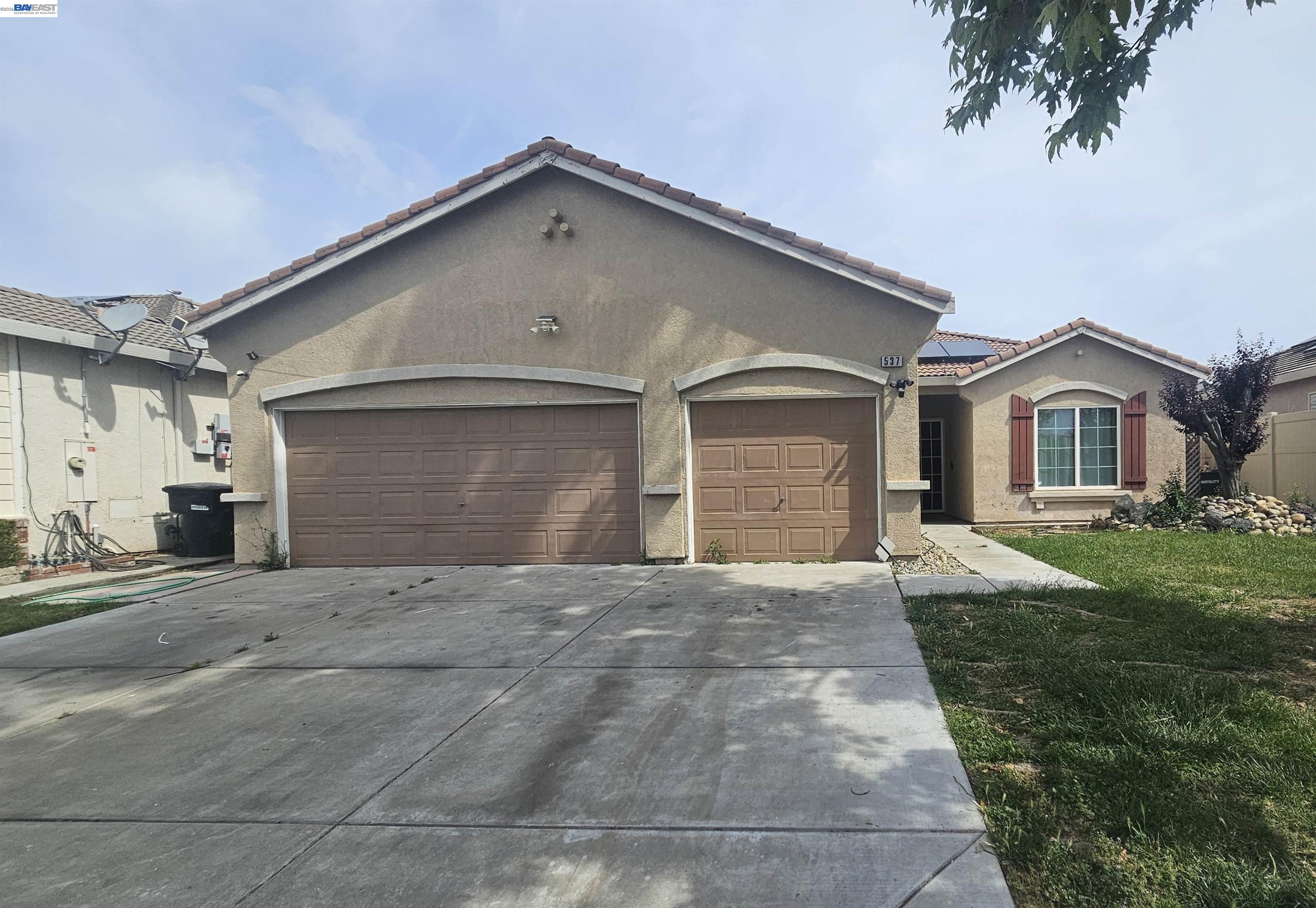 537 Bonanza Drive Newman, CA 95360 - Photo 1 of 16 a front view of a house with a yard and garage
