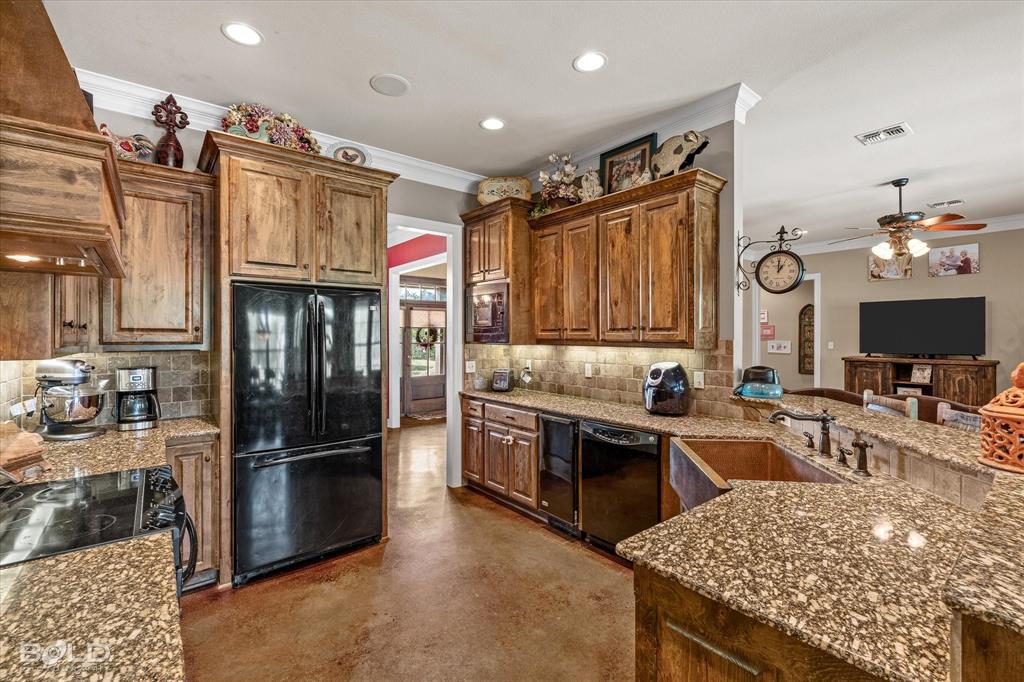 13870 Highway 157 Haughton, LA 71037 - Photo 16 of 40 a kitchen with granite countertop stainless steel appliances and wooden cabinets
