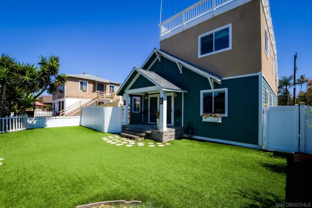 a front view of a house with a yard porch and wooden fence