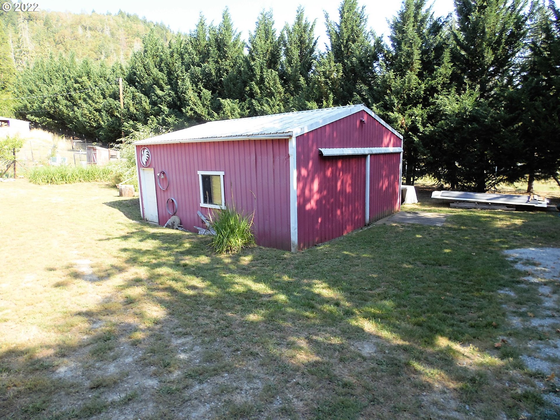 202 Homestake Lane Riddle, OR 97469 - Photo 15 of 31 a view of a backyard with large trees and a small barn