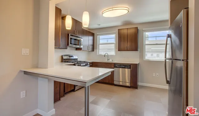 a kitchen with stainless steel appliances granite countertop a sink refrigerator and microwave