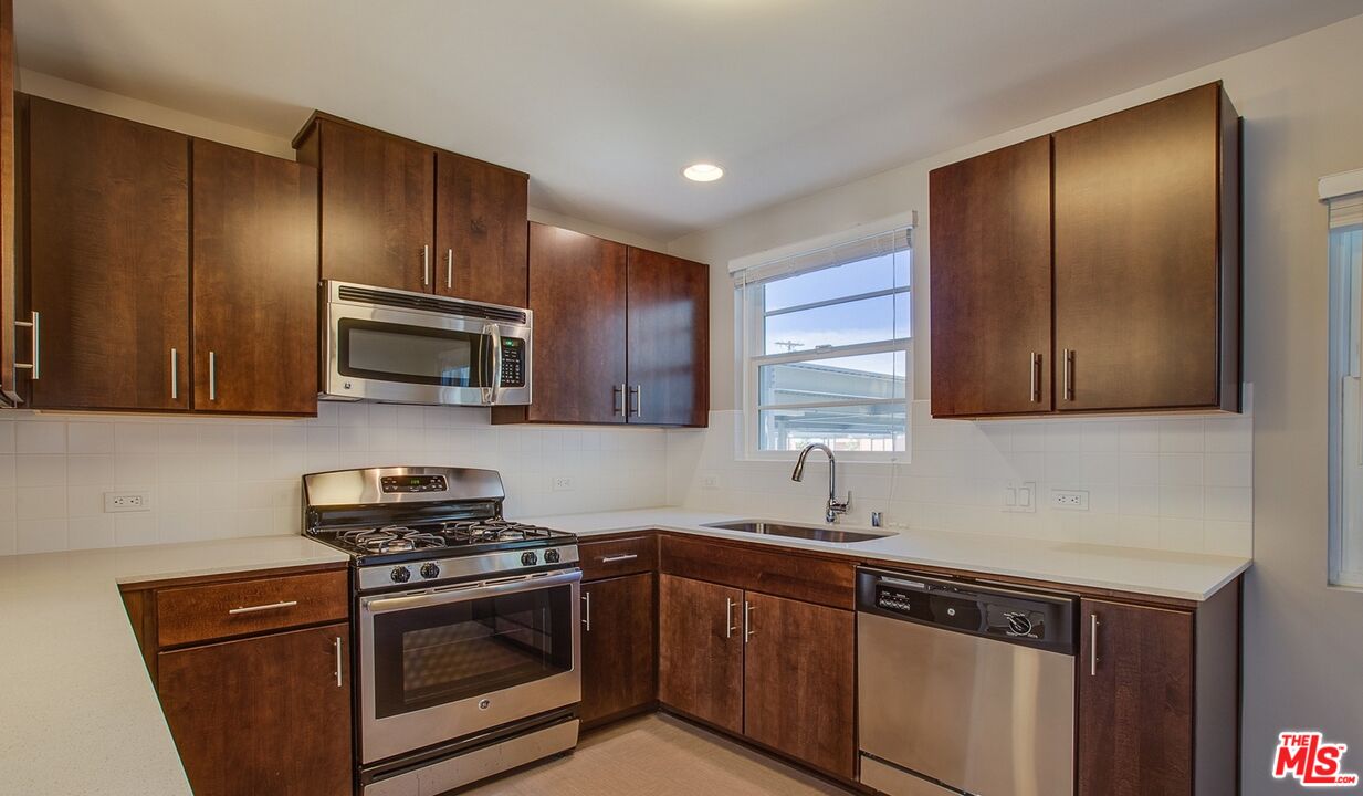 1012 Frederick Street, Unit 1 Venice, CA 90291 - Photo 2 of 10 a kitchen with stainless steel appliances granite countertop a sink stove and microwave