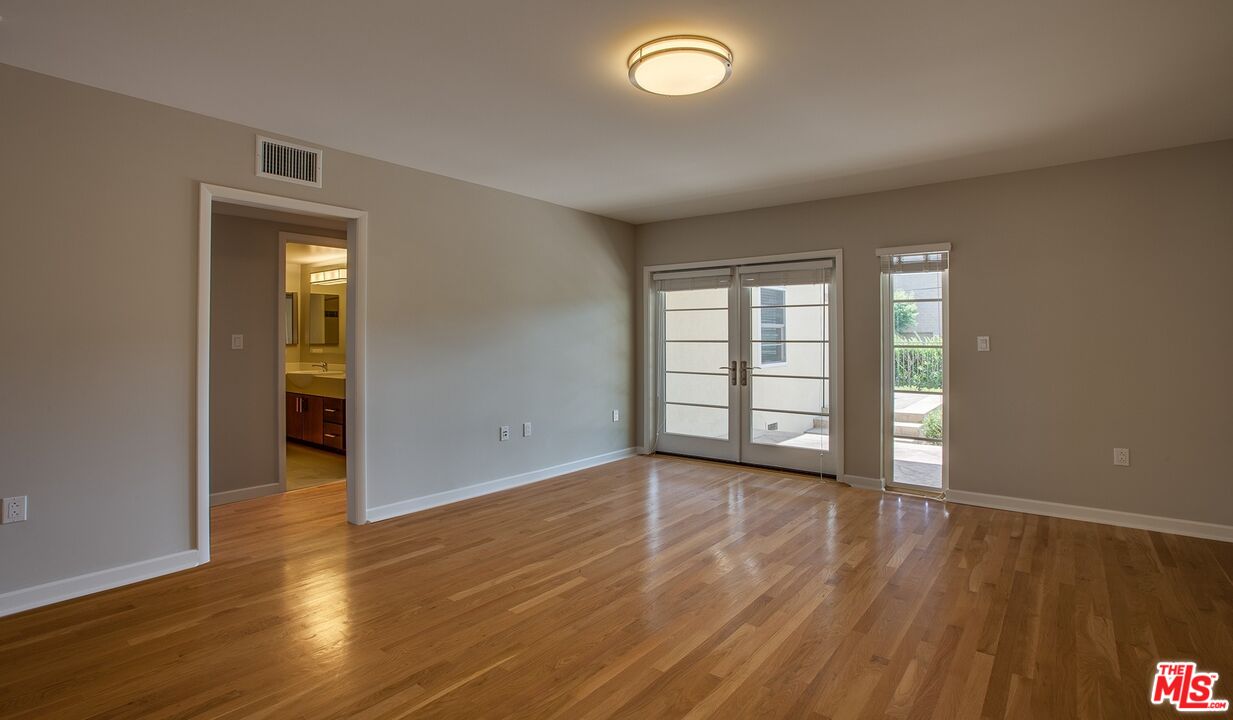 1012 Frederick Street, Unit 1 Venice, CA 90291 - Photo 4 of 10 an empty room with wooden floor and windows