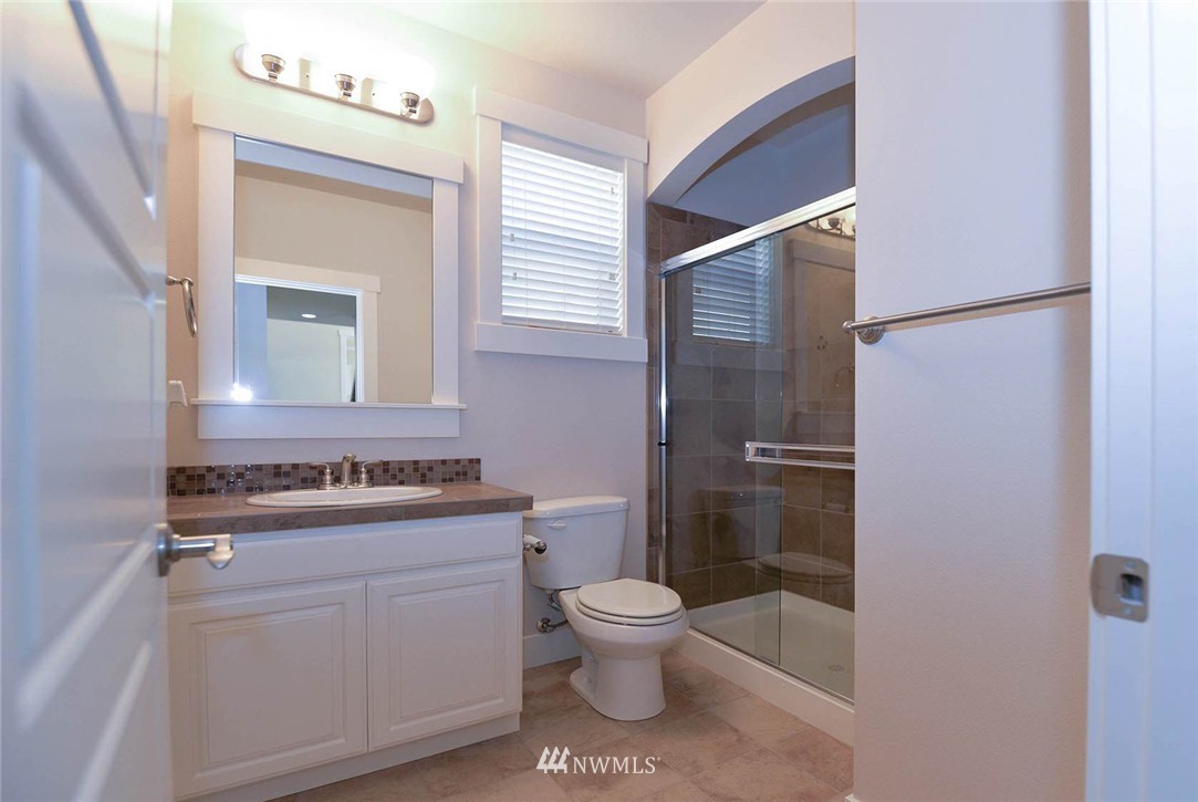 4423 220th Street Southeast Bothell, WA 98021 - Photo 13 of 24 a bathroom with a toilet sink vanity and mirror