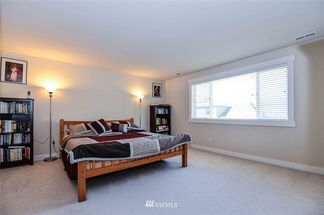 4423 220th Street Southeast Bothell, WA 98021 - Photo 16 of 24 a bed sitting in a bedroom next to a window