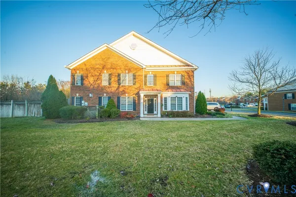 a view of a big house with a big yard and large trees