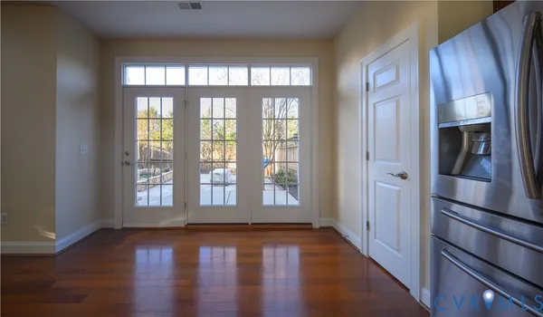 a view of an empty room with wooden floor and a window