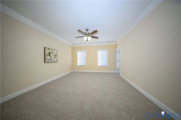 an empty room with windows and ceiling fan