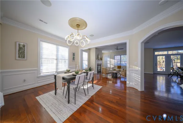 a view of a dining room with furniture a chandelier and wooden floor