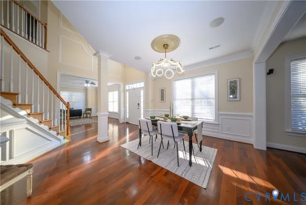 a view of a dining room with furniture a chandelier and wooden floor