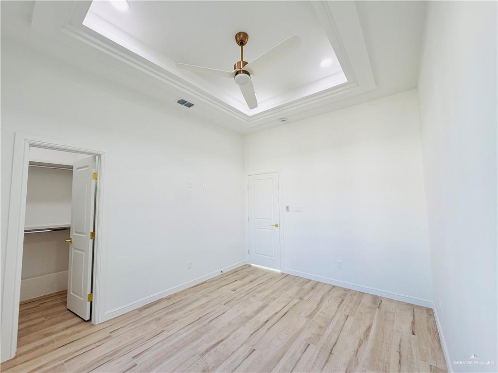 807 Ramirez Street Mission, TX 78573 - Photo 10 of 16 Tray ceiling with recessed lighting, modern ceiling fan, wood tile flooring, and built-in closet shelving