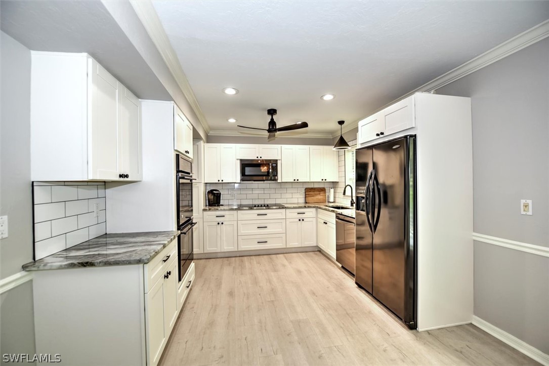 15180 Briar Ridge Circle Fort Myers, FL 33912 - Photo 12 of 35 a kitchen with white cabinets and stainless steel appliances