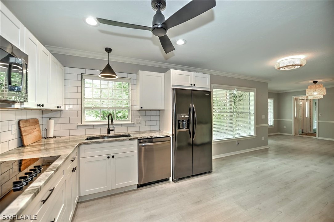 15180 Briar Ridge Circle Fort Myers, FL 33912 - Photo 14 of 35 a kitchen with stainless steel appliances granite countertop a sink a stove a refrigerator cabinets and living room view