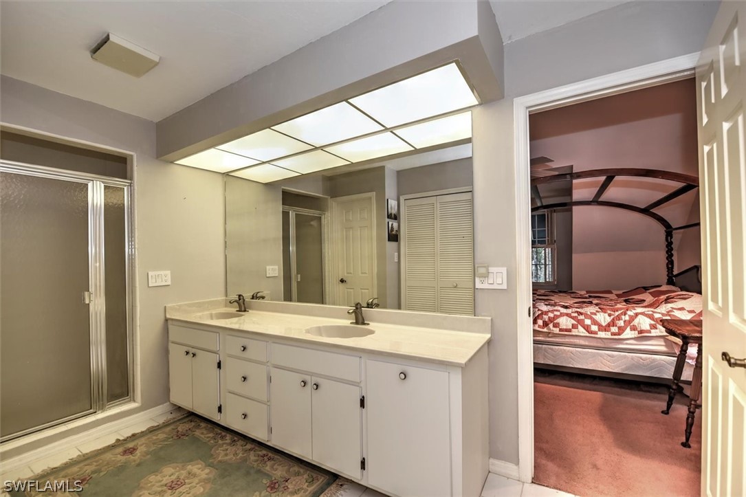 15180 Briar Ridge Circle Fort Myers, FL 33912 - Photo 27 of 35 a en suite bathroom with a double vanity sink and a mirror