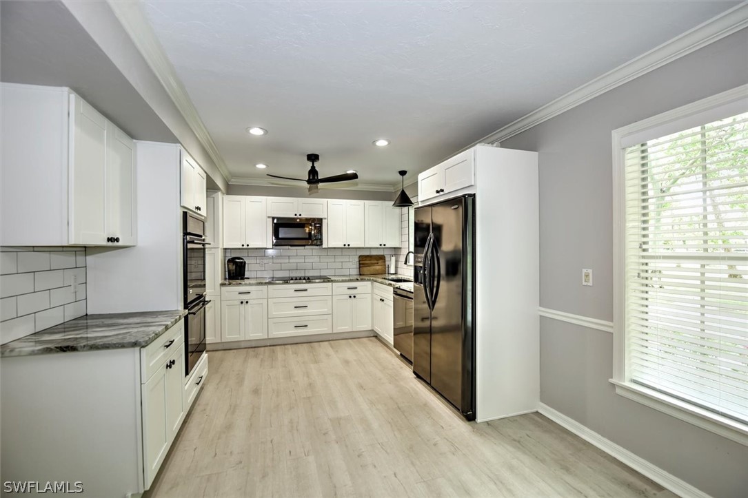 15180 Briar Ridge Circle Fort Myers, FL 33912 - Photo 10 of 35 a kitchen with stainless steel appliances kitchen island granite countertop a refrigerator oven a sink dishwasher and white cabinets with wooden floor