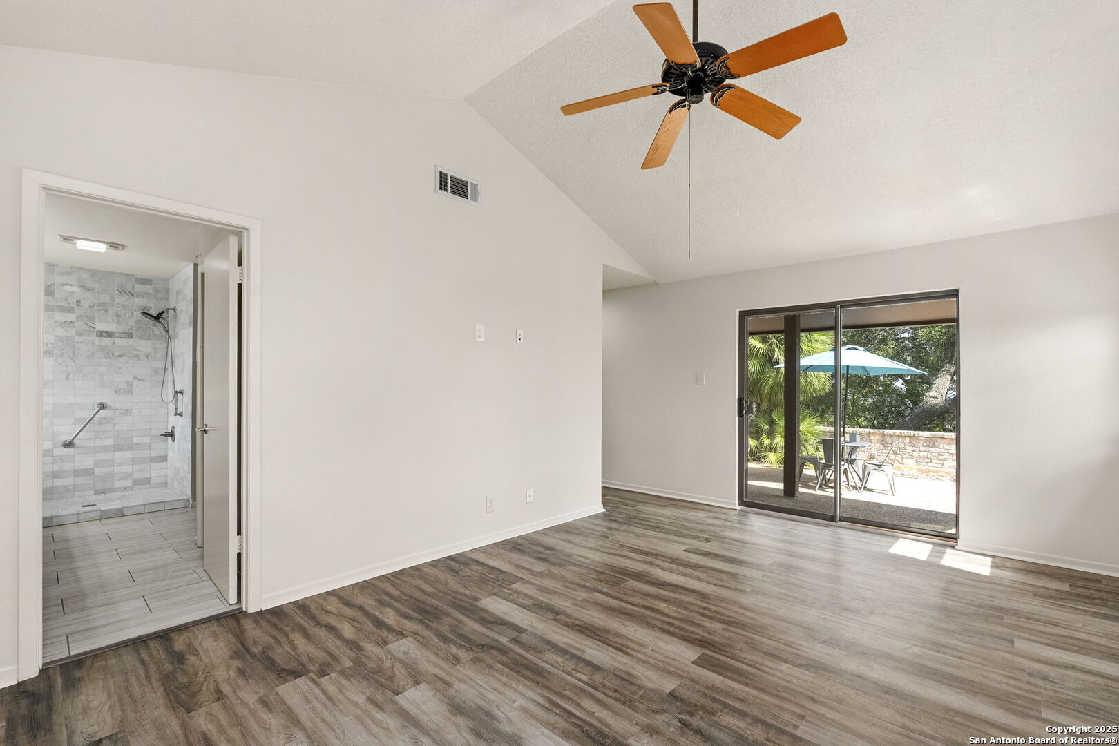 26938 Karsch Road Boerne, TX 78006 - Photo 28 of 60 an empty room with wooden floor fan and windows