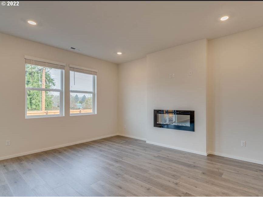 2303 30th Place Springfield, OR 97477 - Photo 5 of 12 an empty room with a wooden floor and windows